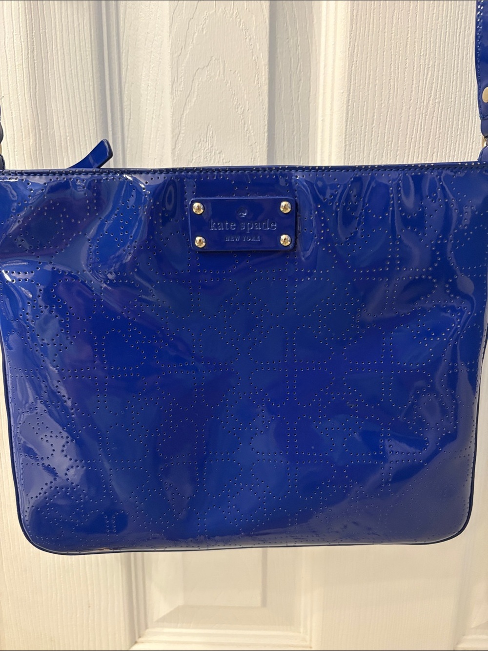 Kate Spade heart perforated patent leather crossbody in cobalt blue.